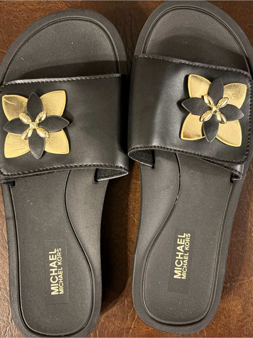 MICHAEL Michael Kors Black Slide Sandals with Gold Floral Emblem